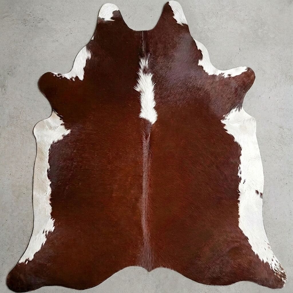 Bruin-witte koeienhuid op een lichte vloer.