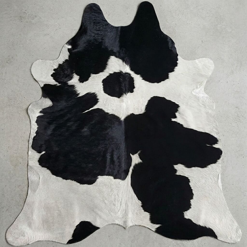 Zwart-witte koeienhuid op een lichte vloer.